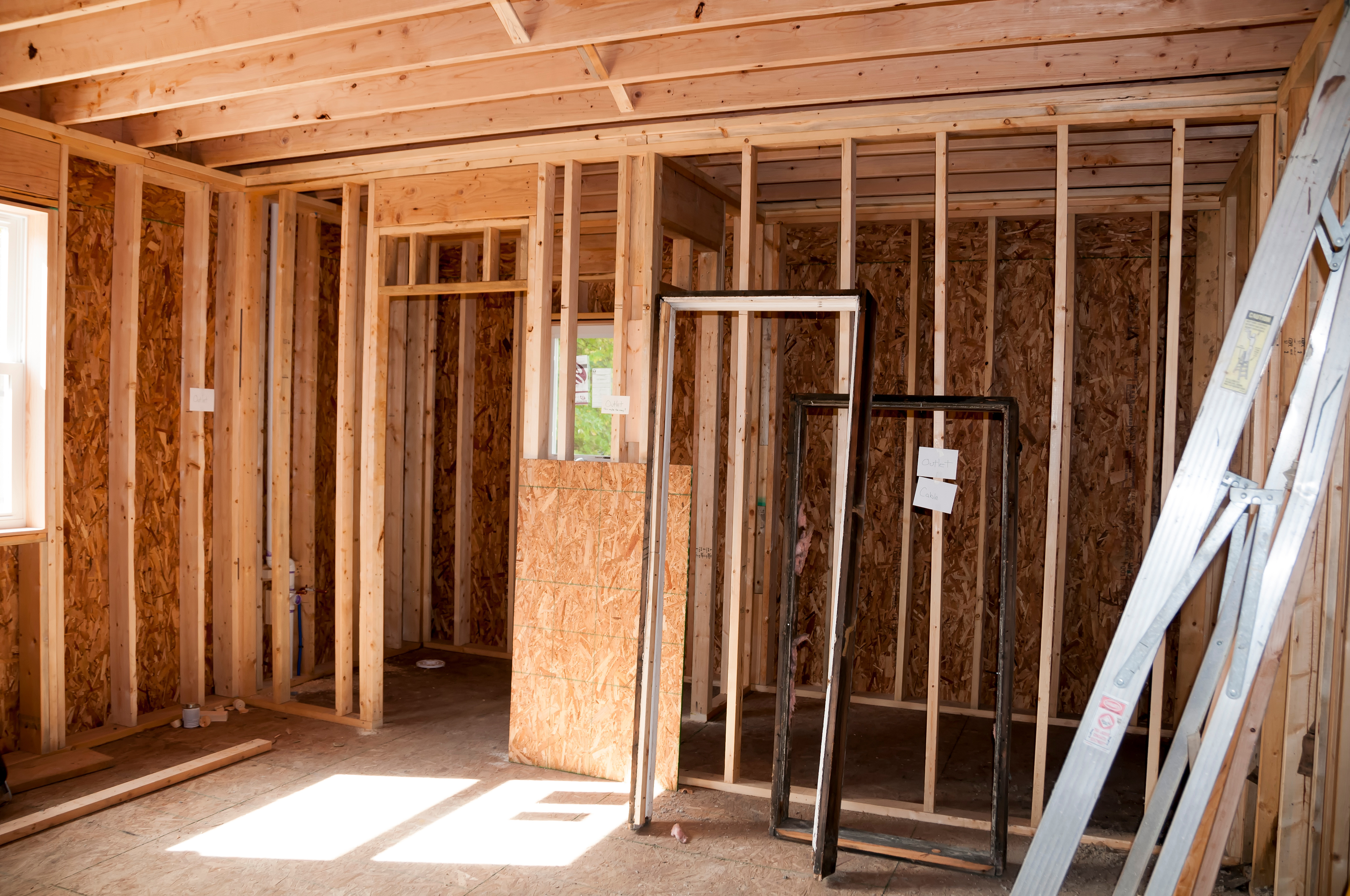 Interior framing of residential home under construction with wooden studs and OSB sheathing